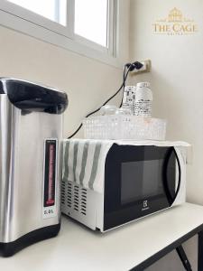 a microwave sitting on a counter next to a coffee maker at The Cage Suites in Bangkok