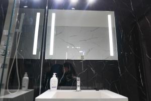 a woman taking a picture of a bathroom mirror at Viento Sur Anfitrionas "Centro" in Puerto Madryn