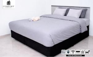 a large bed with a stuffed animal on top of it at Comfort Aparthotel in Chimoio