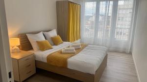 a bedroom with a large bed with yellow curtains at Pau Elégance - 4 Personnes - Pau Hyper Centre - Clemenceau in Pau