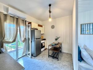 a kitchen with a refrigerator and a table in a room at Rocky Stays - Argostoli Central Studio in Argostoli