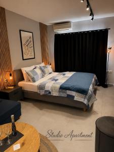 a bedroom with a bed and a table in a room at VARTAN LUX apt in Alexandroupoli