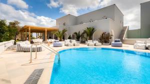 a swimming pool in front of a house at Anamar Santorini in Monolithos