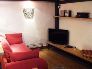 a living room with a red couch and a television at Pitti House in Florence