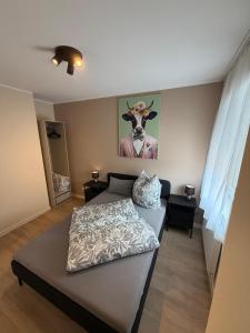 a bedroom with a bed and a picture of a cow at S22 Living in Weingarten (Karlsruhe)