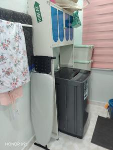 a kitchen with a refrigerator and a trash can at ZIRA STAY PENARIK - Nuha Room in Kampong Ru Sepuloh