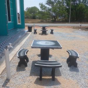 a picnic table and benches in front of a building at ZIRA STAY PENARIK - Nuha Room in Kampong Ru Sepuloh +3 photos