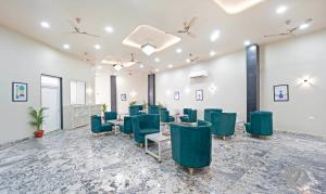 a conference room with green chairs and tables in it at Anandam Hotel in Jaipur