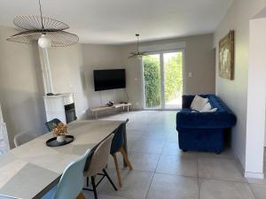 a living room with a table and a blue couch at Maison de campagne in Le Wast