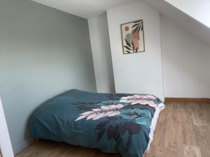 a bedroom with a bed with a blue comforter at Maison de campagne in Le Wast