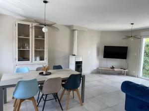 a dining room with a table and chairs and a tv at Maison de campagne in Le Wast +1 photo