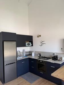 a kitchen with blue cabinets and a stove top oven at שחף על הכנרת in HaOn