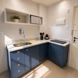 a small kitchen with blue cabinets and a sink at Apartamento Nictheroy in Niterói