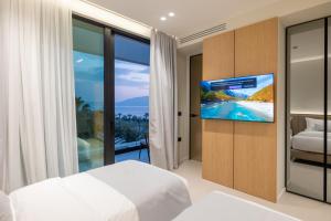 a bedroom with a bed and a tv and a balcony at Padma Hotel in Vlorë +249 photos