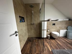 a bathroom with a shower and a toilet at Ferienhaus Kronseeliebe in Lychen +18 photos