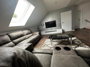 a living room with a couch and a tv at Ferienhaus Kronseeliebe in Lychen