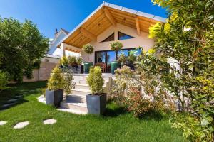 a house with potted plants on the front yard at La Balzac in Dijon