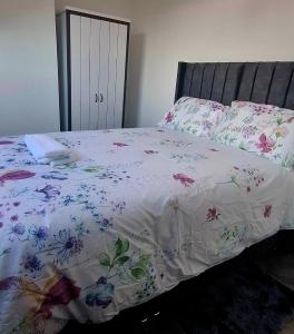 a bed with a white comforter with flowers on it at Stratford Terrace in Beeston