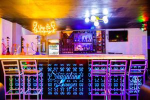 a bar with colorful bar stools and neon lights at Shugaland hotel and lounge in Ibadan