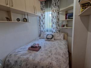 a small bed in a small room with shoes on it at Velvet Nest in Kumanovo