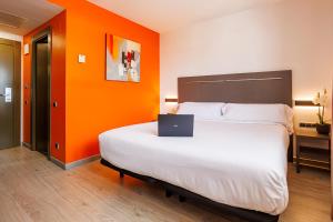 a bedroom with a bed with a laptop on it at Hotel H2 Avila in Ávila +9 photos