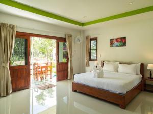 a bedroom with a bed and a sliding glass door at Breeze Bay Villa in Wok Tum
