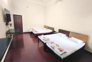 two beds in a room with white sheets and flowers at Lodha Heritage in Ajmer +38 photos