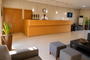 a man standing at a counter in a waiting room at Viana Hotel in Luanda