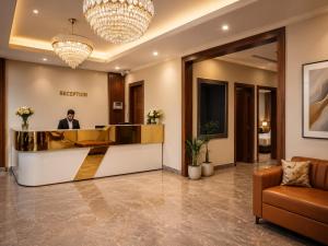 a man in a hotel lobby with a reception desk at Hotel Grand Lucent Mathura-Vrindavan in Gokul