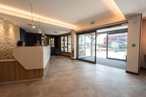 a woman standing at a counter in a lobby at LE VAL MORET Hôtel Restaurant et Spa in Magnant +58 photos