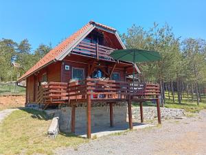a wooden house with an umbrella on a platform at Careva voda 1 in Dobroselica