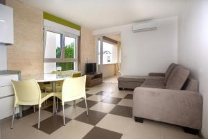 a living room with a table and chairs and a couch at Apartmani Daška II in Njivice