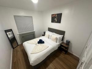 a bedroom with a bed with a hat on it at Spacious 1bed Apartment Close To Town in Ifield