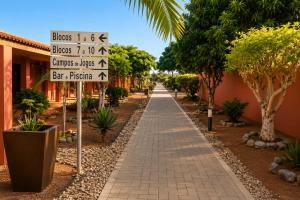 a walkway with signs and trees in front of a building at Viana Hotel in Luanda