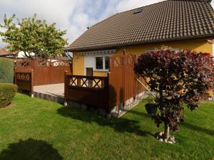 a house with a wooden fence and a yard at Ferienwohnung Kranich - Dranske in Dranske
