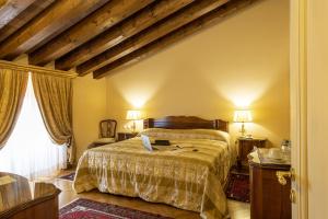 a bedroom with a bed with a laptop on it at Villa Fenaroli Palace Hotel in Rezzato
