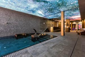 a room with a pool with a star ceiling at Hotel & Spa Ciudad de Binéfar in Binéfar