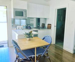 a kitchen with a wooden table and two chairs at Bijoux Beach House in Freshwater +9 photos