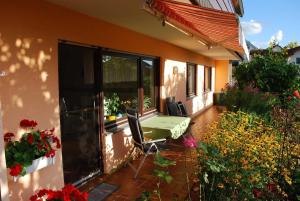 a patio with a green table and some flowers at Ferienwohnung Abendsonne in Neuhof