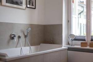 a white bath tub in a bathroom with a window at App Osiria in Kühlungsborn