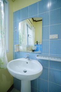 a blue tiled bathroom with a sink and a mirror at Baanrimklong bungalow in Ko Chang +49 photos