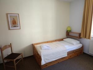 a small bedroom with a bed and a chair at Hermannstr 14-Whg 10 in Kühlungsborn