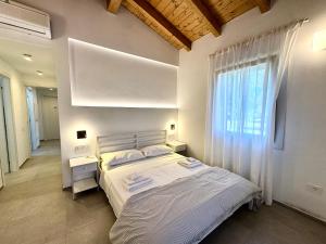 a bedroom with a large bed and a window at FilMa Seagarden Villa in Pula
