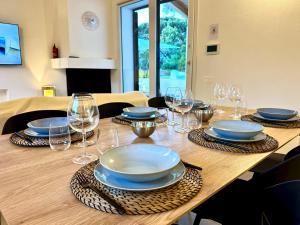 a wooden table with plates and wine glasses on it at FilMa Seagarden Villa in Pula