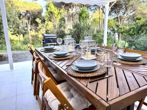 a wooden table with plates and wine glasses on it at FilMa Seagarden Villa in Pula