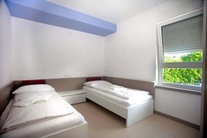 a room with two beds and a window at Apartmani Daška II in Njivice