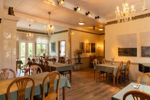 a dining room with tables and chairs and chandeliers at Blankaholms Gästgiveri in Blankaholm