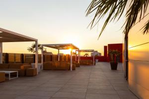 a rooftop patio with couches and tables on a building at Hotel & Spa Ciudad de Binéfar in Binéfar