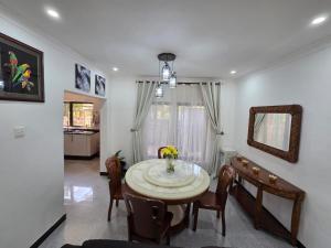 a dining room with a table and chairs and a mirror at Mel's Apartment in Ndola