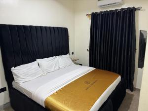 a bed with a black headboard in a room at Shugaland hotel and lounge in Ibadan